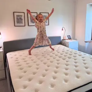 A young girl jumps on top of an Origin LumbarCloud mattress