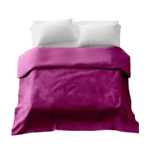 A double bed with two white pillow cases and a large dark pink weighted blanket laying on top
