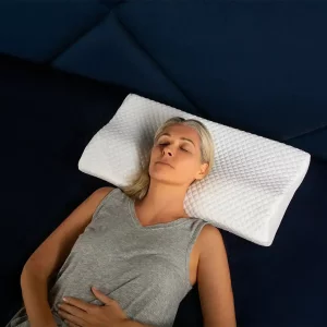 A product image of a woman sleeping on The Original Groove® Pain Relief Pillow
