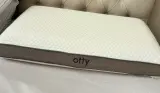 A close up of the Otty Deluxe Pure Pillow on a tester's mattress