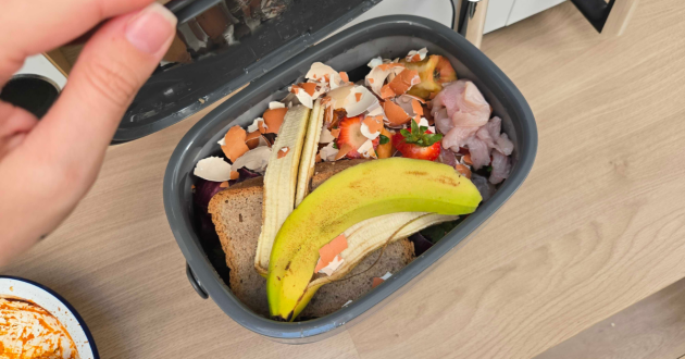 The OXO Good Grips Easy-Clean Compost Bin filled with food waste
