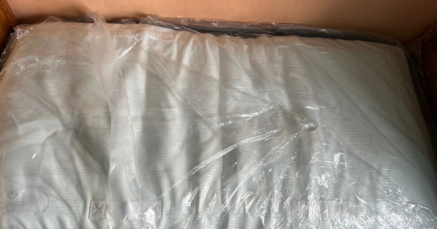 Panda Hybrid Bamboo Mattress laid on a wooden single bed frame while still covered in clear plastic