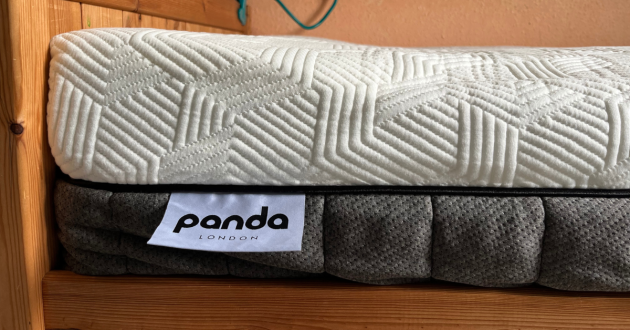 Close-up of the mattress corner showing the white textured cover, grey side panels and Panda London label