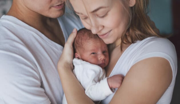 A mum and dad holding new-born baby
