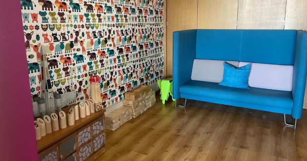 a room with bright wallpaper and a blue sofa