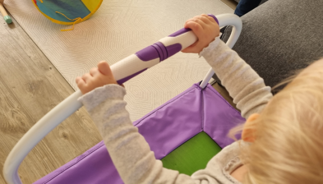 Child holding onto Plum trampoline grip handle