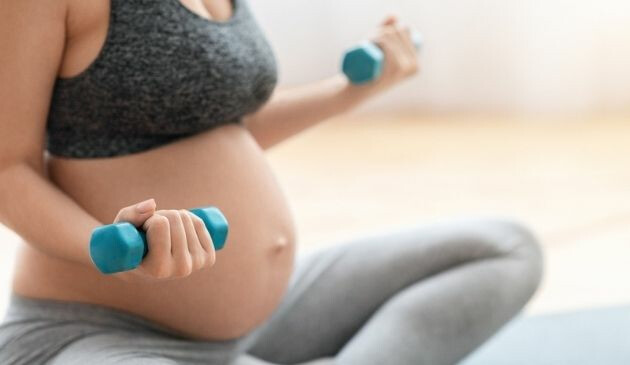 pregnant woman lifting dumbbells