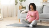 pregnant woman sitting on yoga mat