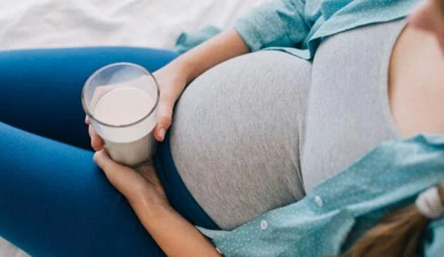 Pregnant woman holding a glass of milk
