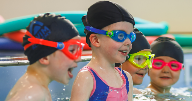 Children in swim hats and goggles on a Puddle Ducks swimming lesson