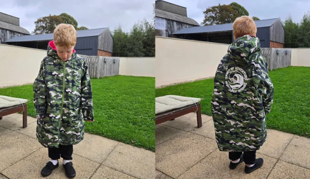 Front and back view of child in garden wearing the Regatta junior changing robe