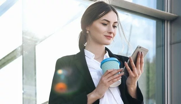 woman holding reusable coffee cup