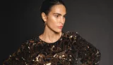 A model wears a sparkly dress against a black background for Monsoon