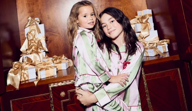 Two sisters wearing matching pyjamas from River Island for Christmas