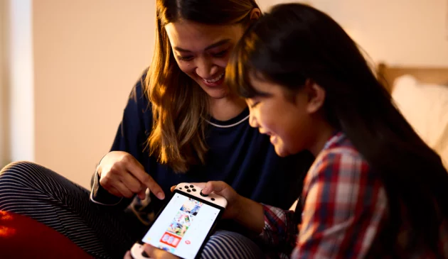 Mother and daughter playing a Nintendo Switch OLED together