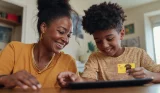 A mother and son shopping online using the child's GoHenry debit card