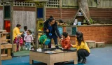 A mum greets her child in the playground at nursery