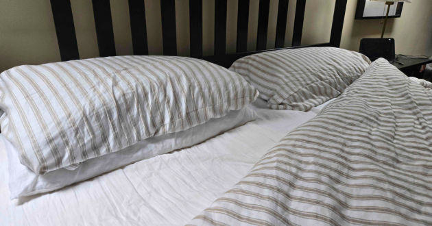 A view of the Secret Linen Store French Ticking Stripe Natural bedding set with another fitted sheet