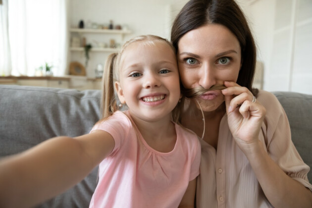 A little girl and her mother pull faces at the camera for a fun selfie