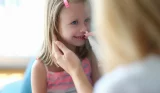 A child receives a nasal vaccine at the doctors