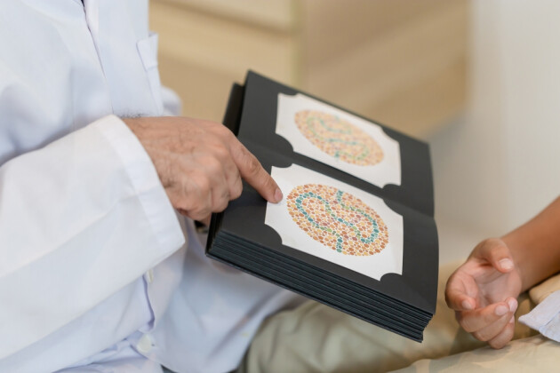 An optometrist giving a colour blinded test via a book to a child