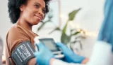 A woman is having her blood pressure taken at the doctors