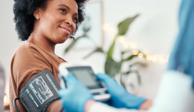 A woman is having her blood pressure taken at the doctors