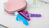 Sex toys fall out of a storage pouch on top of a white cabinet