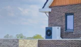 A heat pump atop a UK home wall in the sunshine