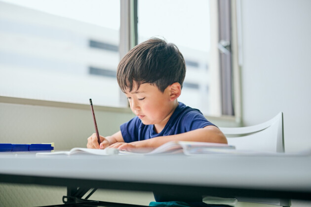 A boy is writing at school