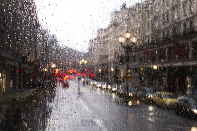 A picture of a street in London through a window that's covered in rain