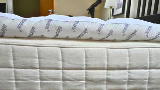 A side view of the Silentnight Airmax mattress topper atop a mattress