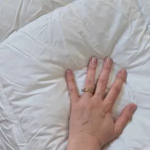 A hand presses down on the Simba Hybrid 3-in-1 Duvet to show how soft it is