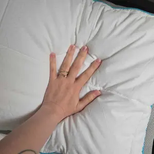 A hand squishes the Simba Hybrid Pillow