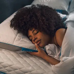 A woman sleeps on the Simba Hybrid Pillow