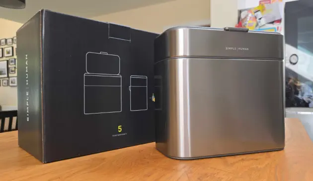 The simplehuman Compost Caddy on top of a kitchen counter next to its packaging box