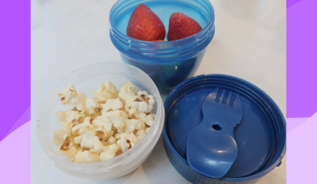 Sistema Snack Capsule To Go in use, storing popcorn and strawberries