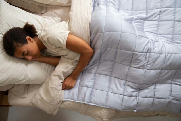 A woman sleeps on a mattress comfortably under a duvet