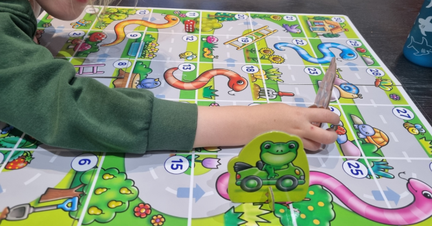 Child playing My First Snakes & Ladders