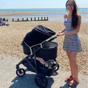 Mum and pram on beach with SnoozeShade Original attached