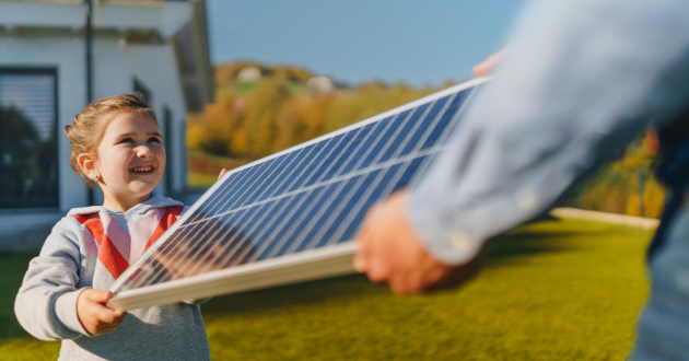 a girl holds a solar panel