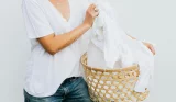A woman in a white t-shirt with a laundry basket