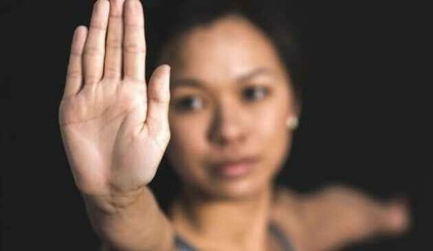 Woman holding up hand to signal 'stop'