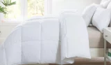 a bed with white pillows and duvet