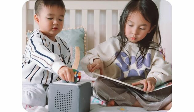 two children play with a toniebox