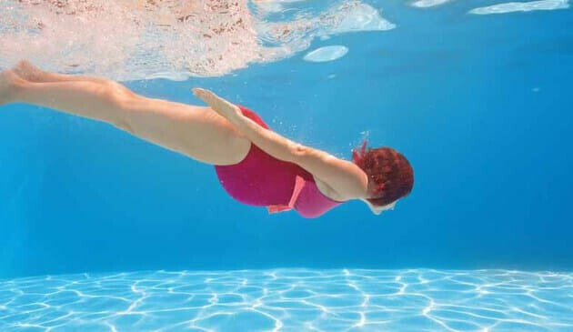 Pregnant woman swimming under water