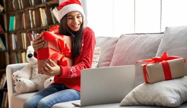 teen holding christmas present while on virtual call