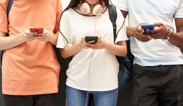 Three teenagers on their smartphones