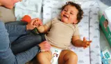 Smiling baby lying on changing mat