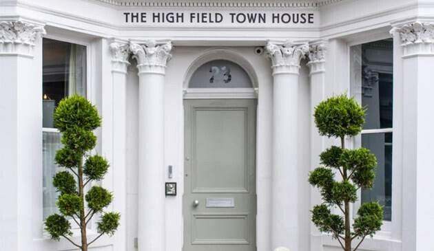 A picture of the front door and sign outside of the High Field Town House.